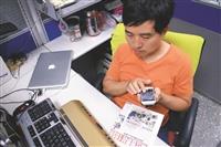 視障資源中心工程師張金順示範語音隨身助理APP，將淡江時報報導以攝影鏡頭轉化為語音服務。（圖／本報資料照）