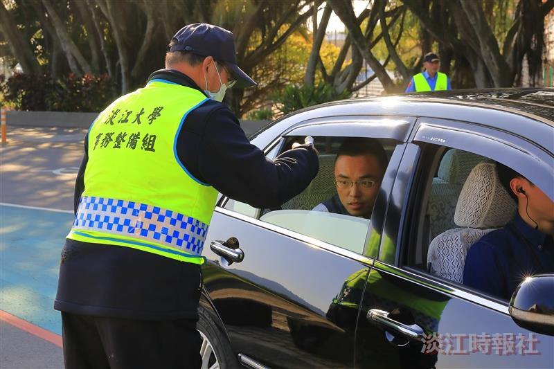 大門口管制站，訪客開窗讓警衛量額溫