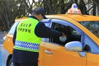 大門口管制站，計程車乘客開窗讓警衛量額溫