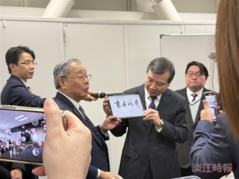 Ambassador to Japan I-Yang Li (right) holds a tablet for Carrie Chang Fine Arts Center Director Ben-Hang Chang (left) while he explains e-Pen calligraphy.