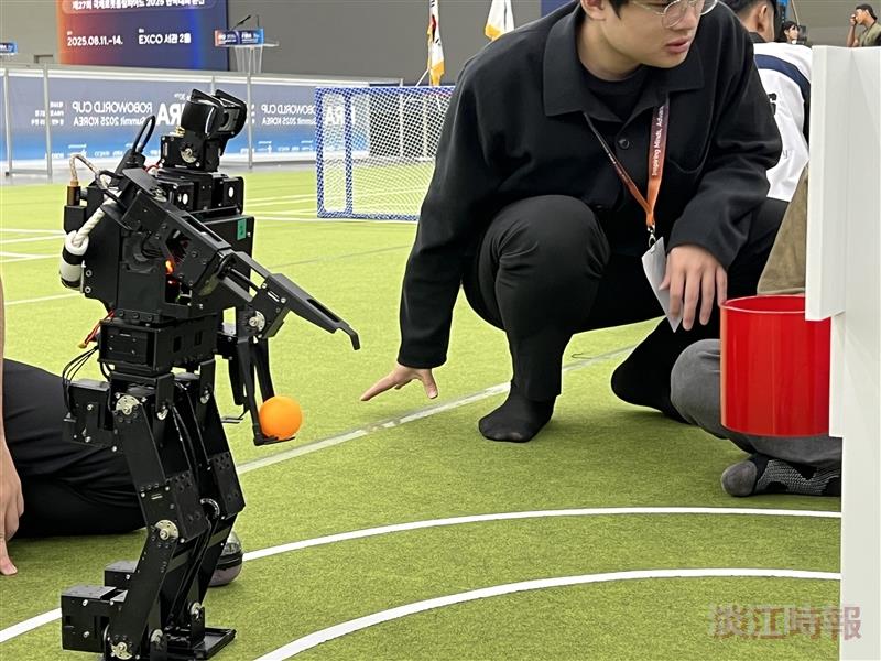 In the basketball event of the small humanoid robots, a robot is about to take a 3-point shot.