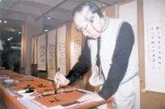 文 學 週 展 覽 會 場 ， 中 文 系 老 師 王 仁 鈞 當 場 揮 毫 。 （ 攝 影 \ 韓 兆 容 ）