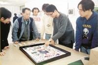 大 傳 四 莊 坤 儒 （ 右 二 ） 向 參 觀 的 師 生 解 說 他 的 作 品 「 留 言 、 流 言 、 留 顏 」 。 （ 攝 影 \黃 文 政 ）