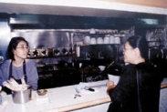 檢 查 小 組 成 員 對 餐 廳 工 作 人 員 宣 導 戴 帽 子 及 口 罩 的 重 要 性 。 （ 攝 影 \韓 兆 容 ）
