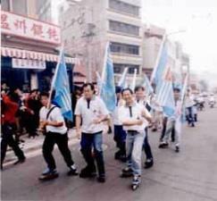 溜冰社社員拿著校旗陪跑。