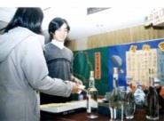 金門校友會展出高梁酒，連女同學都有興趣。（圖\劉育孜）