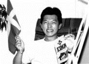 ▼王忠銘右手持瑞典國旗，左手拿著瑞典一種有醬油味的糖果。