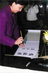 書法暨篆刻聯展邀請校長張紘炬、副校長張家宜主持開幕剪綵，並當場在簽名簿上揮毫。（記者劉育孜攝）