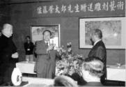 校長張紘炬手持之書頁即銅雕圖像，右為佐藤理事長，左為文錙藝術中心主任李奇茂。