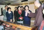 行政副校長張家宜（左四）與本校多位一級單位主管與同學參觀佛教文化展，聆聽見達法師解說各項佛器用途。（圖/張佳萱攝）