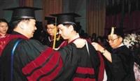 校長及院長一一為博士畢業生整理帔巾、移帽穗，頒授學位。（記者陳震霆攝）