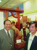 校長張紘炬（圖左）參加吳榮賜（右）在台北101大樓舉行的木雕展開幕，對其作品極為讚賞。（劉冠君提供）