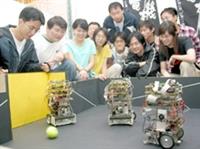 三個機器足球員正全力較勁，同學們都來一睹世界冠軍丰采。（攝影�陳震霆）