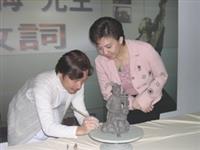 陶藝家劉銘侮二十餘分鐘便捏製出拉琴的樂師，並允諾上釉及燒製完成後，將送給校長做紀念。（記者林靜妤攝影）