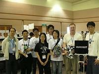 本校人型機器人組的五位同學與翁慶昌教授（左一）、加拿大隊指導老師（右二），以及加拿大隊學生代表（左二），於比賽會場中合影留念。（電機系提供）