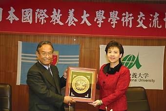 校長張家宜（右）精心挑選鑲有彩釉雙鶴的景泰藍飾品，在上週三兩校簽訂姊妹校儀式中，贈送給姐妹校國際教養大學中山鳥嶺雄校長。（攝影�郭展宏）