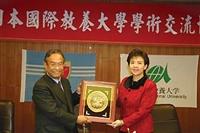 校長張家宜（右）精心挑選鑲有彩釉雙鶴的景泰藍飾品，在上週三兩校簽訂姊妹校儀式中，贈送給姐妹校國際教養大學中山鳥嶺雄校長。（攝影�郭展宏）