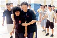 排球課堂上，老師正在傳授同學如何拉筋，和同學笑鬧成一片。（圖�陳振堂）