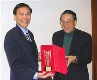 中華電信訓練所所長曹善信頒發獎座給學校，由學術副校長馮朝剛代表校長接受。