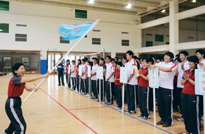 上週三校長張家宜為全國大專校院運動會授旗，幫本校9隊參賽選手加油打氣，體育室主任謝幸珠接下校旗後，揮舞校旗高喊：「淡江，加油！」（圖�邱湘媛）