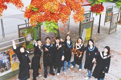 沐浴鳳凰花雨，畢業生揮別校園。（攝影�王文彥）