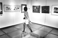 文錙藝術中心現展出「今日有約」畫展，徜徉其中的她，正仔細品嘗繪畫之美。