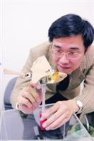 右圖為楊龍杰對「拍翼式微型飛行器」，於起飛前檢查零件。（圖�涂嘉翔）