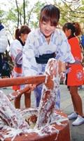 日文系學生於14日穿著日本傳統服裝示範搗麻糬，並將搗好的麻糬分送給師生享用。（圖�陳振堂攝）