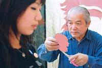 頭像剪影師傅專注地剪著人像，邊剪邊凝視女同學的髮梢，做最後的修飾。（攝影�涂 嘉翔）