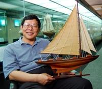 第70萬位造訪海博館幸運兒，為本校校醫兼組長談遠安，捧著船身長40公分、高30公分的「奮勇號」開心的笑。（陳振堂攝）