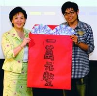 產經四陳文玨連續兩屆獲得創意瘋潮大賽冠軍，高興地從校長張家宜手中領取獎金一萬元。（攝影�黃士航）