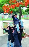 ↑Ya！咱們畢業了！同學興奮地在鳳凰樹下慶祝畢業，他們即將揮別校園，展開新的人生！（攝影�邱湘媛）