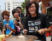 「嘿！就是你！快來加入我們吧！」西洋音樂社社員打鼓、彈奏樂器炒熱氣氛，抓住同學好奇目光。（下圖�黃士航）