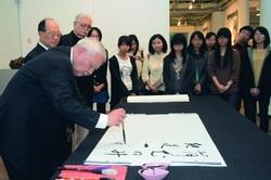 詩魔洛夫（左一）精通書法，14日執筆揮毫，創辦人張建邦（左二）、文錙藝術中心主任李奇茂（左三）及同學們屏氣凝神，欣賞大師風采。（攝影�洪翎凱）