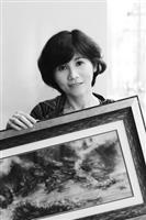 楊靜宜與她的得意作品《幻象桃源行》，她說：「2006年初，做了視網膜剝離的治療雷射，整個過程幻舞著雷射曼妙的光譜，我忘卻疼痛，一心用力記住這前所未有的驚豔，遂演成這件作品的雲光。」（圖�王文彥）