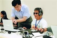 菲律賓師資來校學盲用電訪系統，指導人員正細心為菲國人員解惑。（圖�吳佳玲）