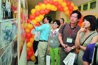 資工系系友看著牆上過往照片回憶從前。（攝影�吳佳玲）