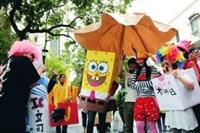 資傳系講師盧憲孚於12日在淡水校園帶領學生，穿著奇裝異服在校園內來回穿梭，宛若巴西嘉年華。（攝影�林奕宏）