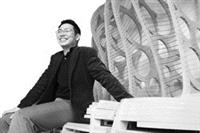 陳宏銘坐在自己設計的作品上，自信地微笑。（攝影�林奕宏）