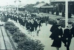 民國57年6月，首屆新制夜間部畢業生遊園，當時宮燈道旁的柏樹還是幼小樹苗，現已高過屋簷。（本報資料照片、曾煥元翻拍）