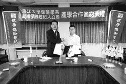 保險系與錠嵂保險經紀人股份有限公司合作，2009年5月12日在L522，由保險系系主任高棟梁（右）與該企業處經理劉大維代表簽定「產學合作協議」，提供學生實習、獎學金等機會。（圖�本報資料照片）