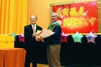 13日「春之饗宴」舉行抽獎活動，圖為創辦人張建邦頒發獎品給得獎校友。（攝影�曾煥元）