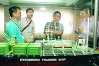 航海、輪機系友返校相聚，看著輪船模型比手畫腳回憶當年。（攝影�張豪展）