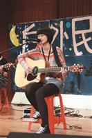 吉他社戶外民歌表演遇雨不減興致，不插電演出展現演奏實力。（攝影／梁琮閔）