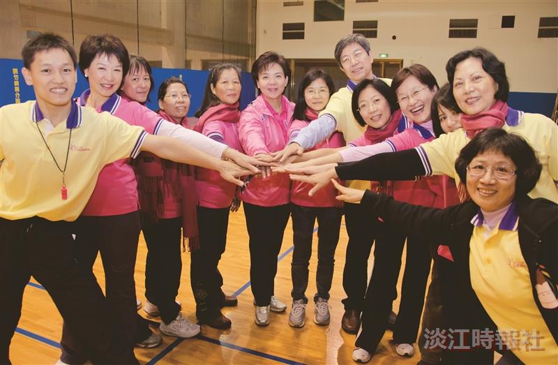 女聯會因雨在體育館在階梯進行健走，由校長張家宜（左六）、教育學院院長暨女聯會理事長高熏芳（右四）、體育長暨女聯會副理事長蕭淑芬（左二）與獲得全勤獎的同仁一同歡呼，人資長鄭東文、體育處講師陳瑞辰也為獲獎者加油。（攝影／羅廣群）