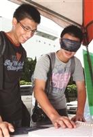在無障礙週系列活動中，學生戴起眼罩體驗視障者閱讀點字書。（攝影／林奕宏）