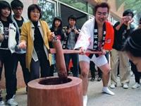 女聯會與日文系於24日在外語大樓前舉辦「日本新年文化--搗麻糬大會」，日籍生今福宏次示範如何搗麻糬，吸引百餘名師生圍觀。（攝影�劉瀚之）