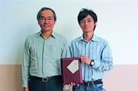化材系碩一林承澤（右）參加台灣化工學會程序設計競賽，獲得全國冠軍，高興地拿著獎牌與指導教授陳錫仁（左）合照（攝影�王家宜）。
