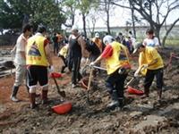 本校學生在屏東羌園國小的操場清理泥土，以協助該校學生能順利開學。（圖�課外組提供）