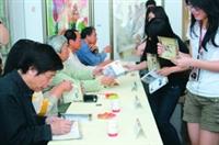 「亞洲當代繪畫聯盟展」開幕茶會上，許多師生蜂擁而至，拿著畫冊請香港畫壇大師司徒乃鍾（左一）等畫家簽名。（攝影�吳佳玲）